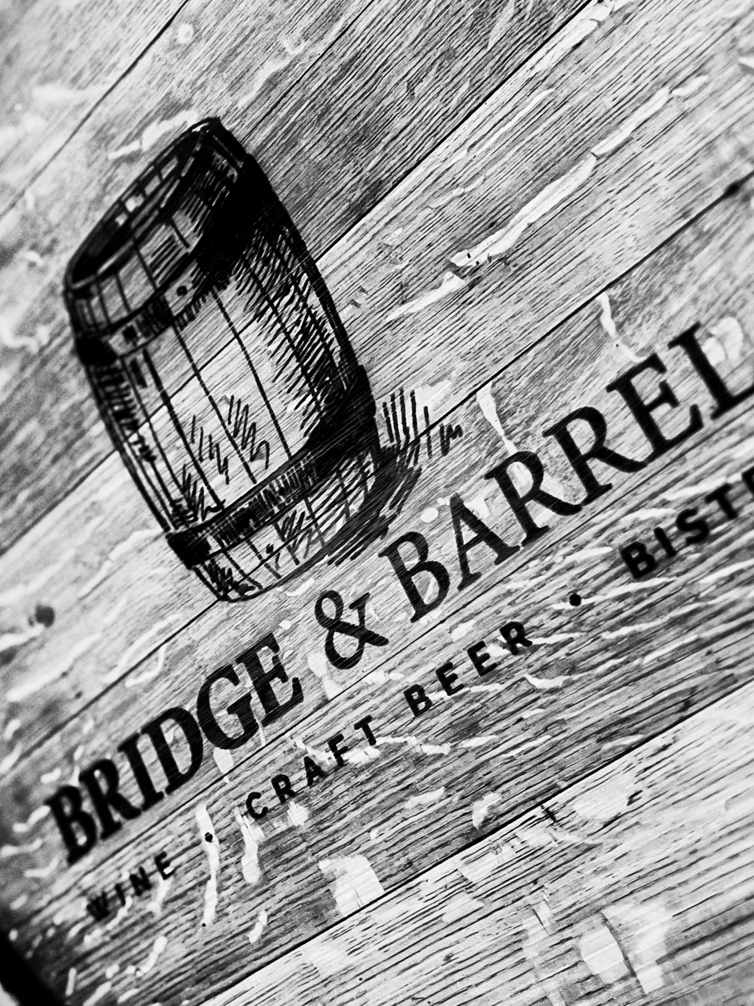 Stylish restaurant sign for Bridge & Barrel featuring a wine barrel illustration
