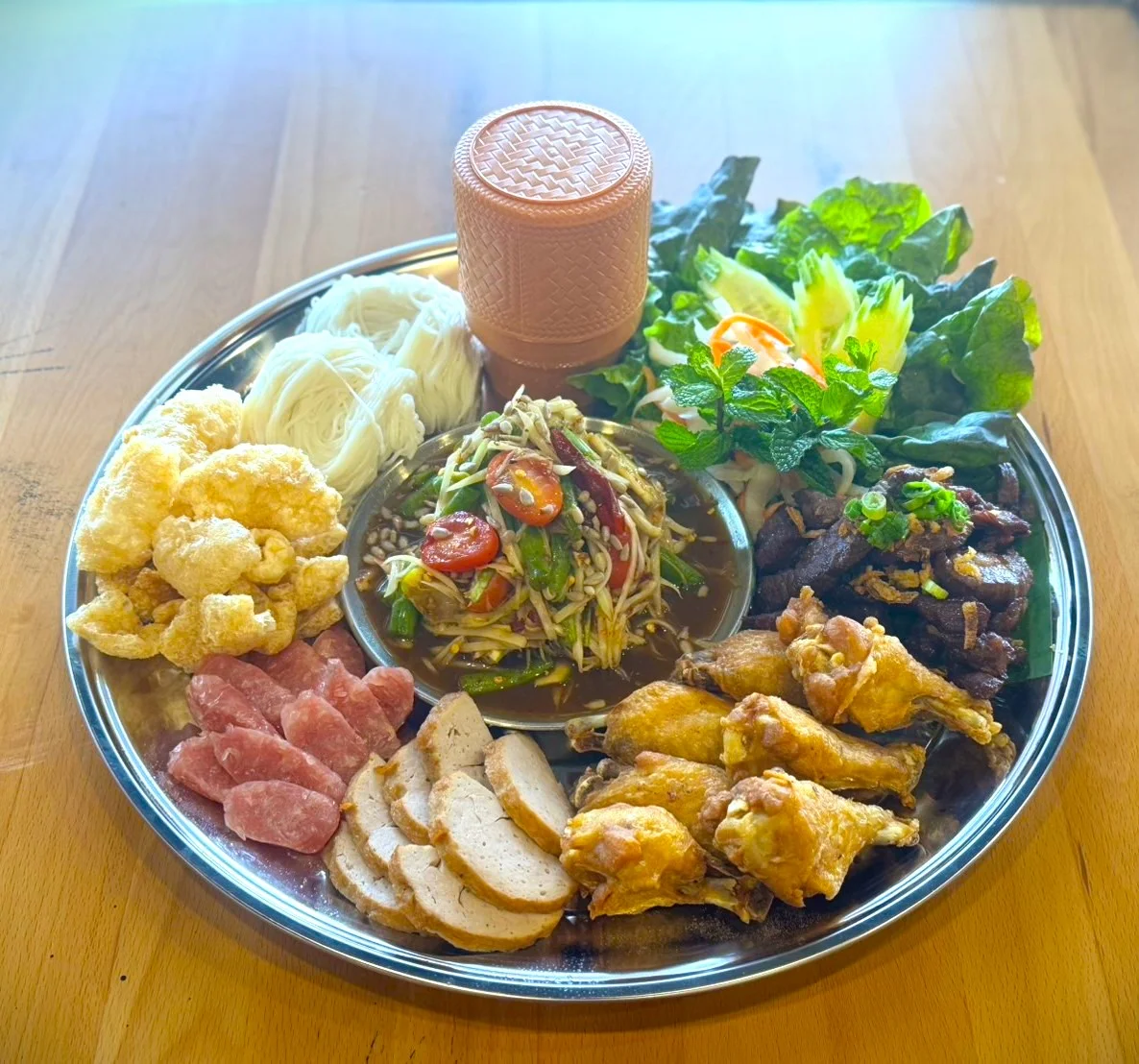 Laotian som tam platter with grilled meats and fresh herbs