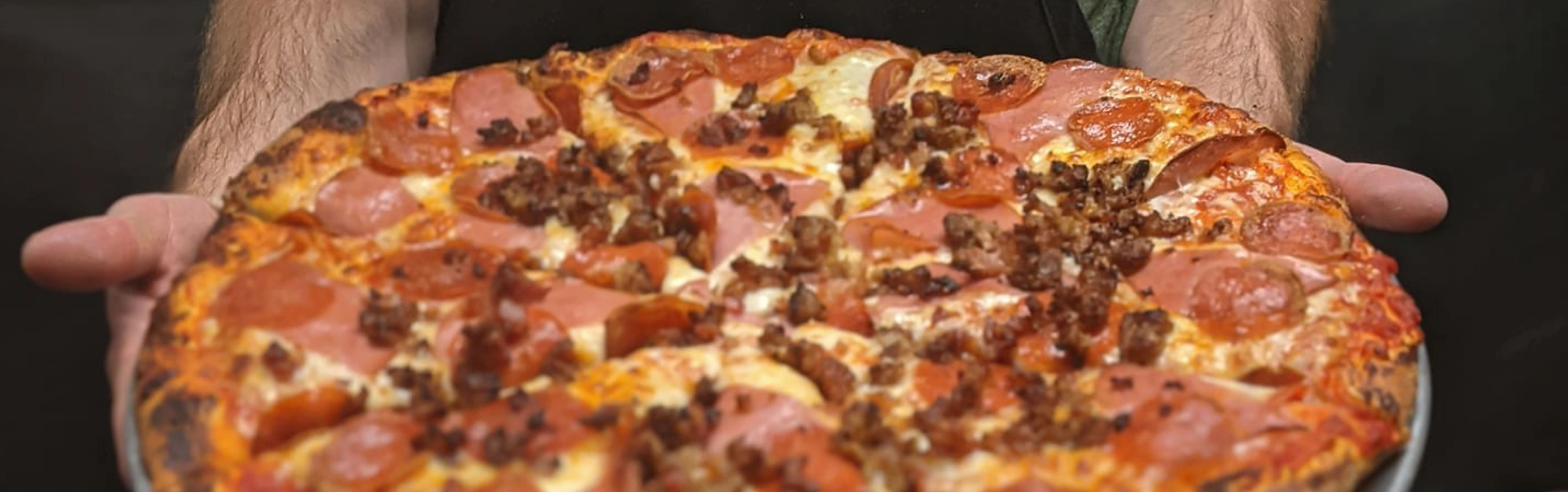 Loaded pepperoni and sausage pizza from a pizzeria
