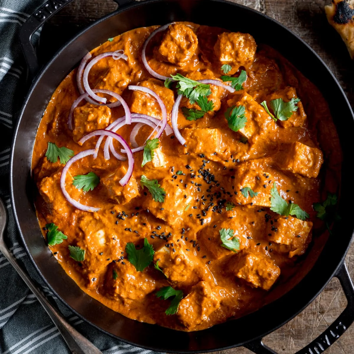Creamy Indian paneer butter masala in a black serving dish
