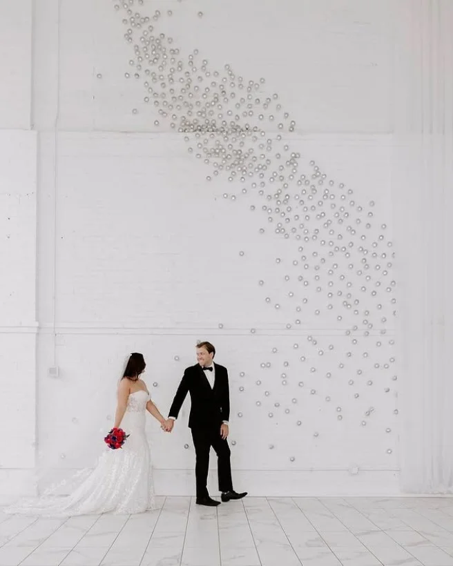 Elegant ballroom setting for a couple's event with decorative lighting.