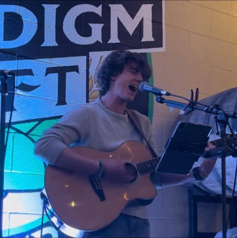 A lively open mic night at a restaurant with performers and an audience.