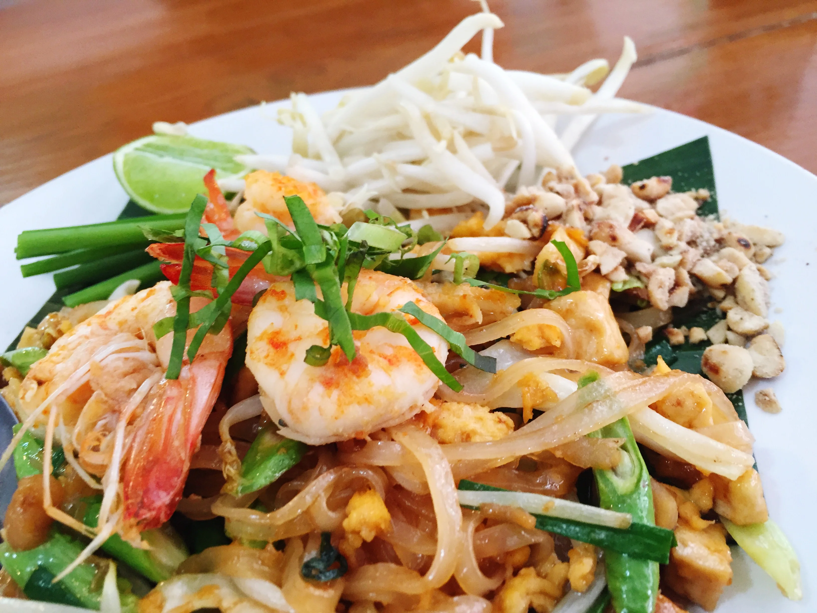 Plate of Thai pad thai with shrimp and fresh herbs