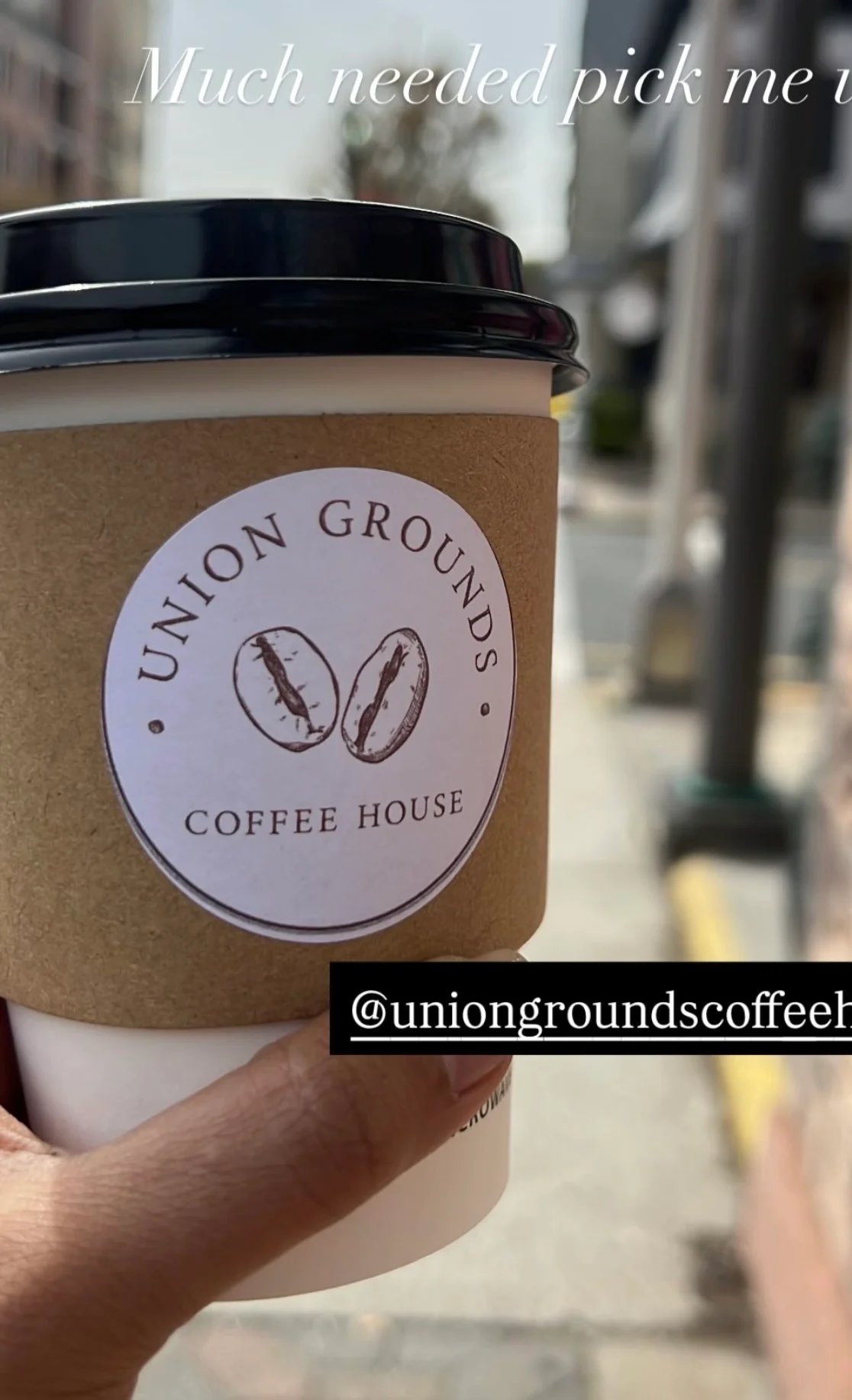 Coffee cup from Union Grounds Coffee House on a sunny street
