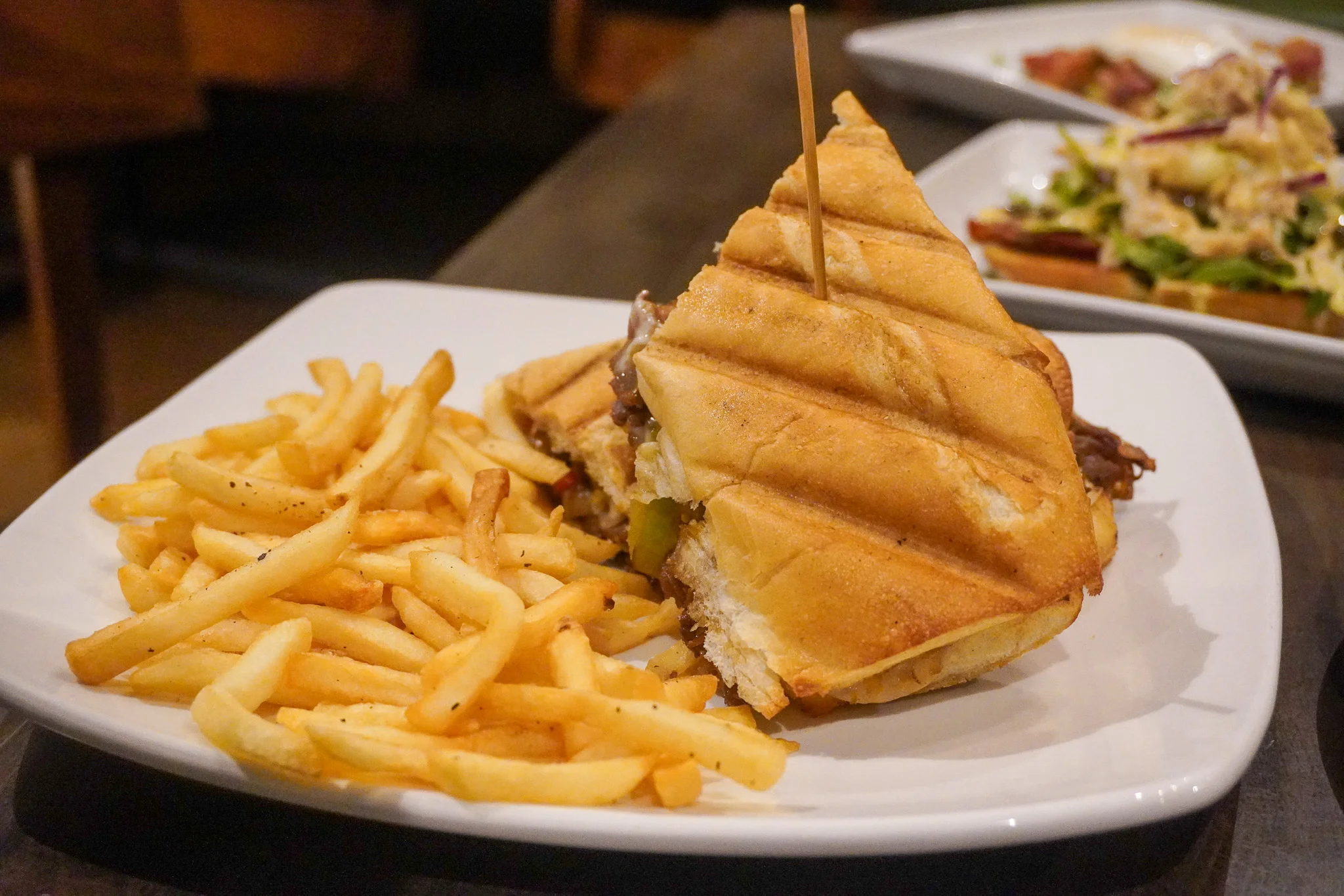 Grilled panini sandwich with fries, a classic comfort food dish