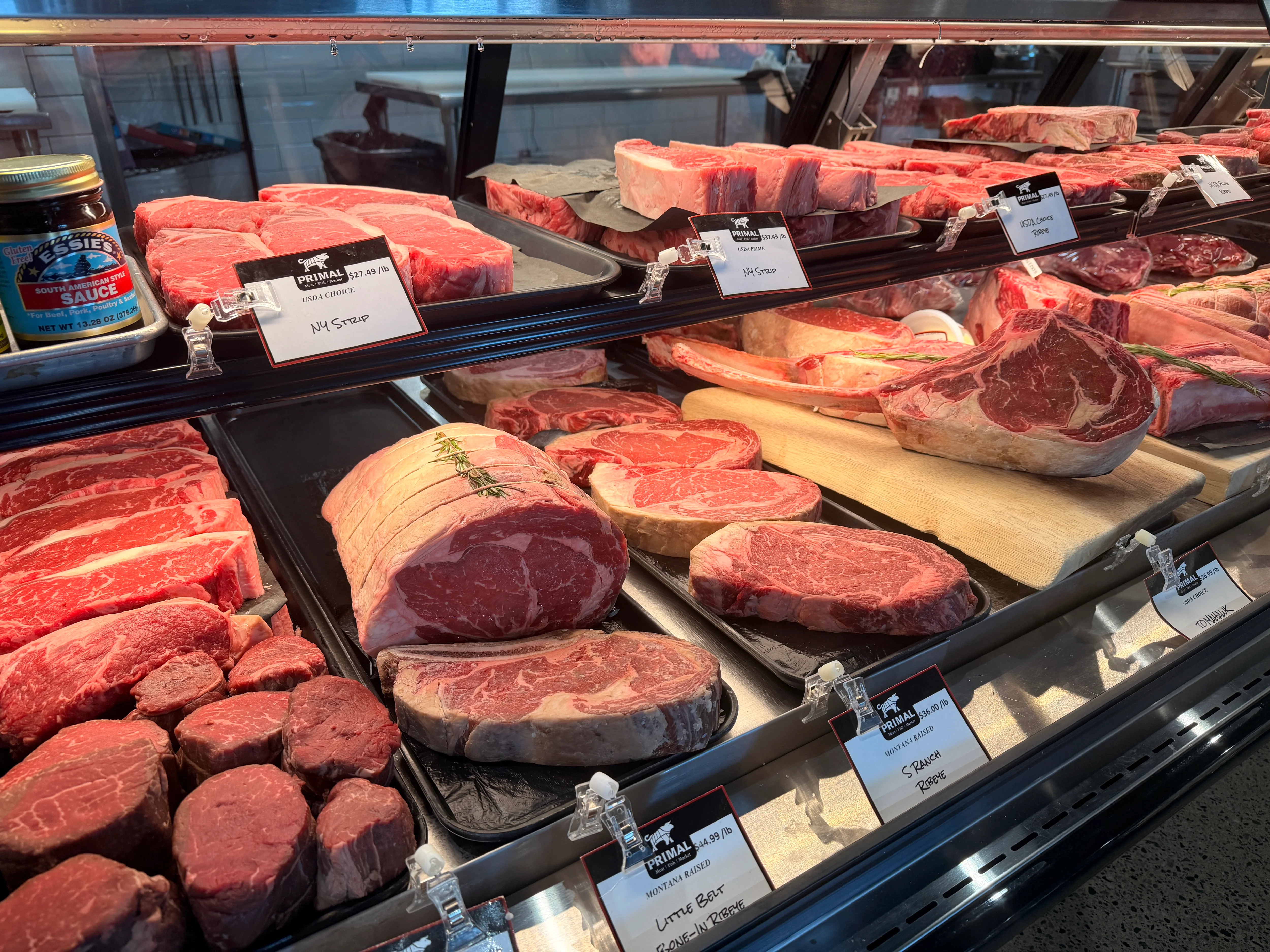 Premium raw beef steaks displayed in a butcher shop meat case