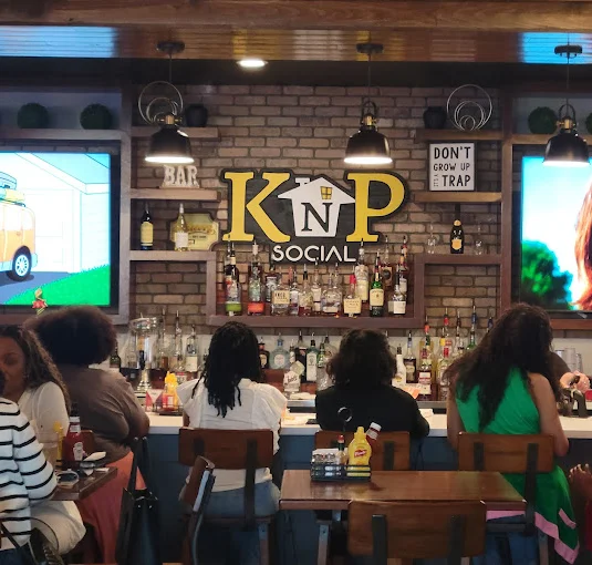 Interior of KNP Social restaurant with bar and patrons enjoying drinks.