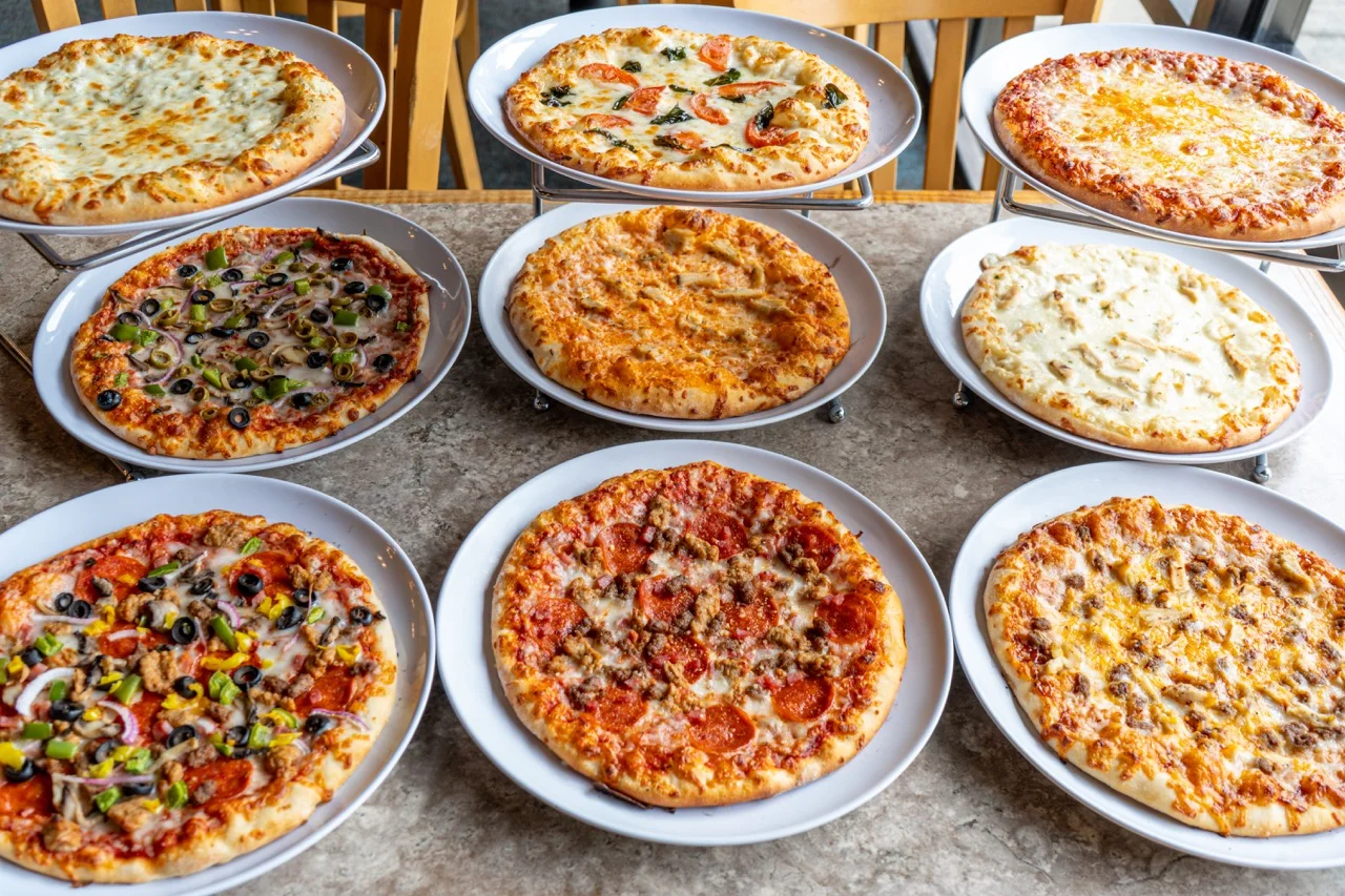 Variety of pizzas including pepperoni and veggie styles