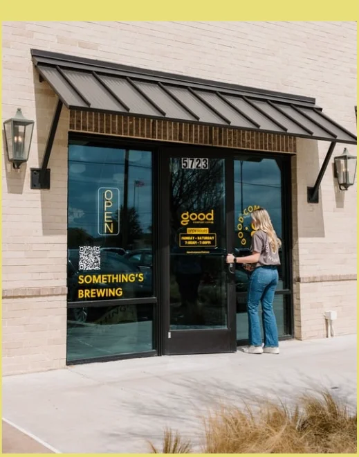 Entrance of a cozy café with open hours displayed