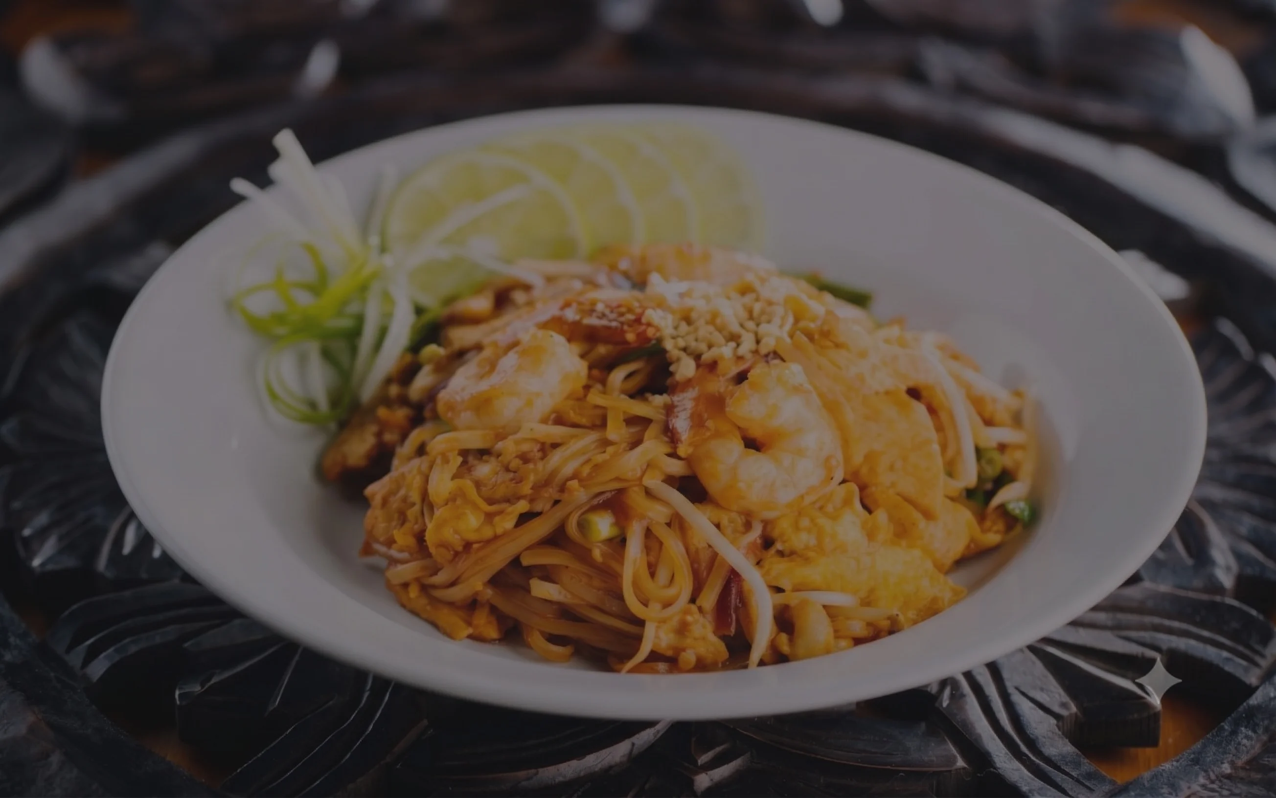 Plate of Thai pad thai with shrimp and lime