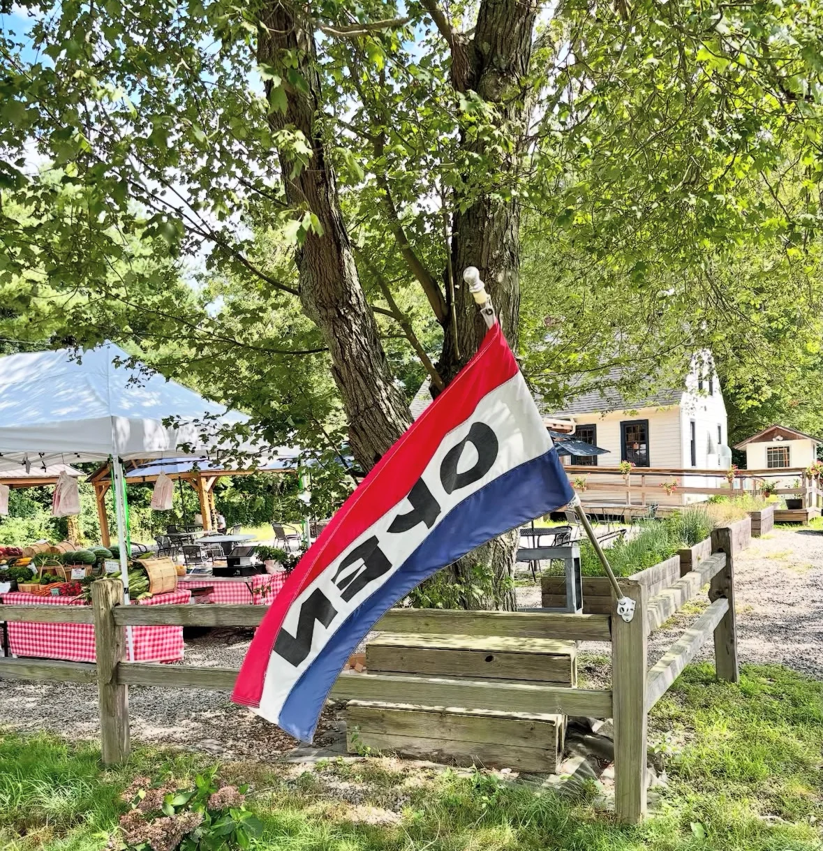 Open flag at a rustic outdoor market with fresh produce
