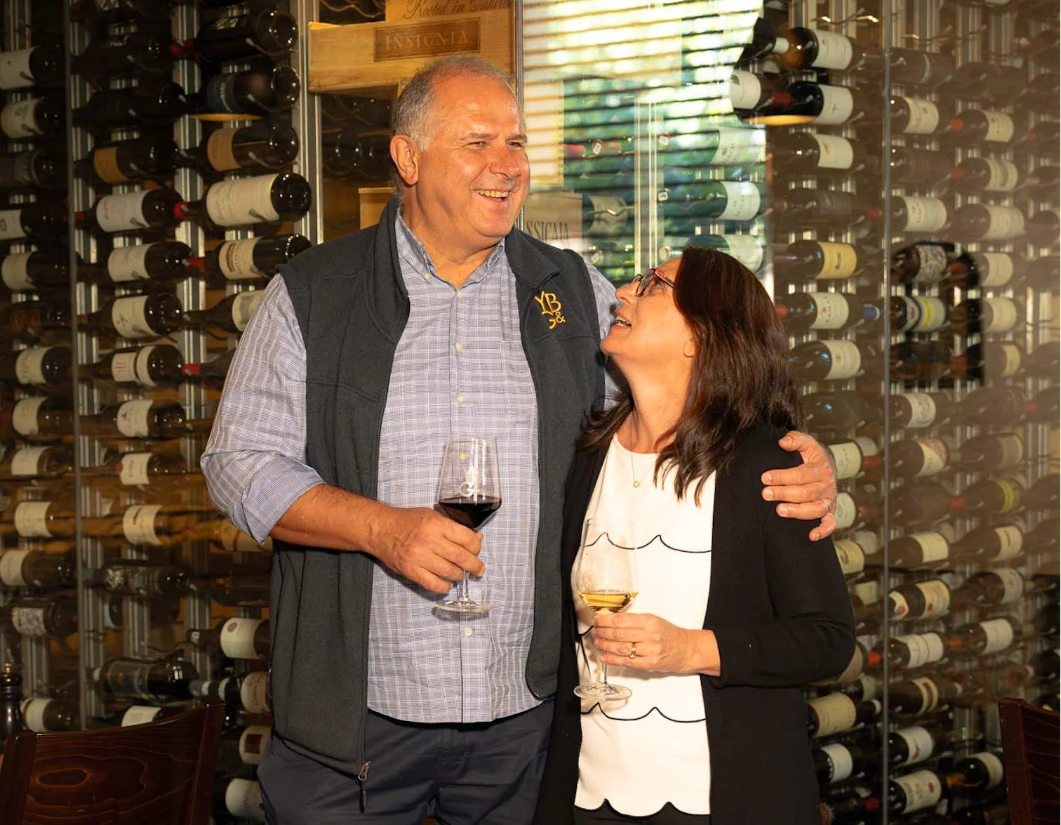Couple enjoying wine in a cozy restaurant with a wine cellar backdrop