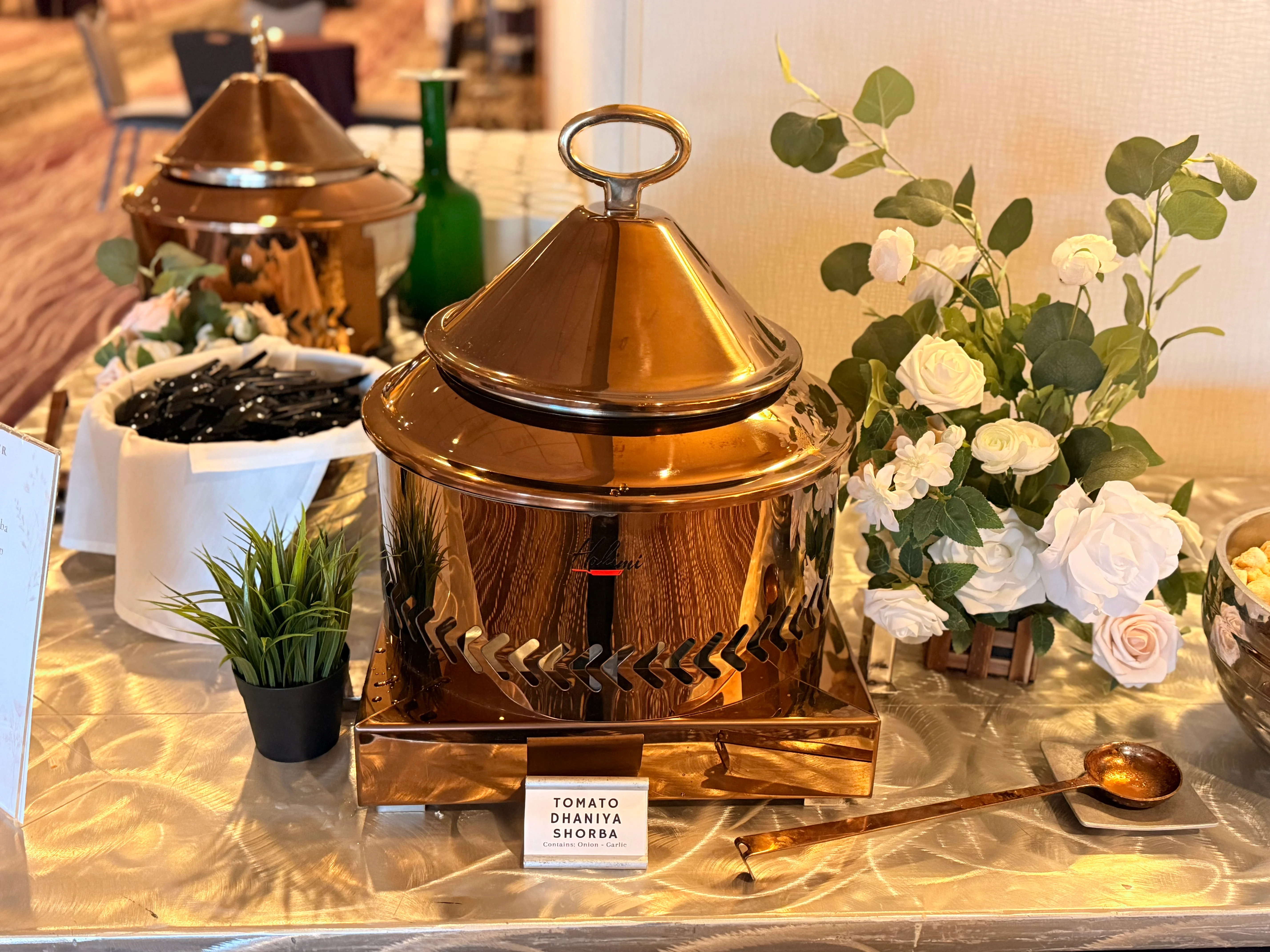 Copper pot of Indian tomato dhaniya shorba on a buffet table