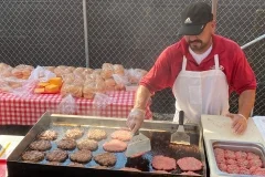Grilling classic American hamburgers at a food stall