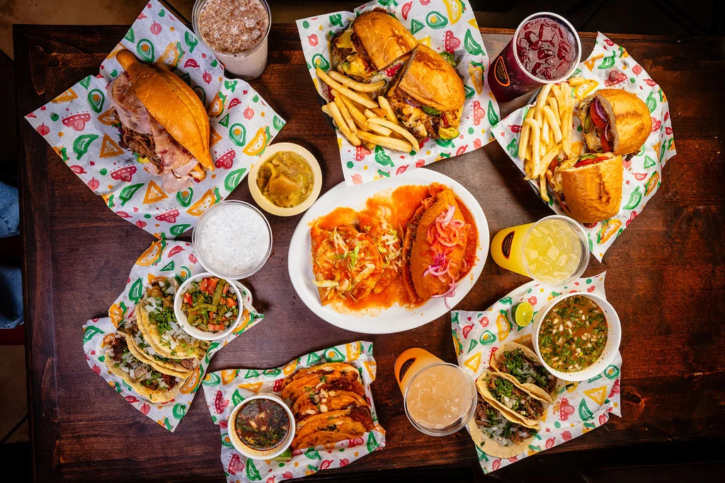 Assorted Mexican tacos and sandwiches on a colorful table