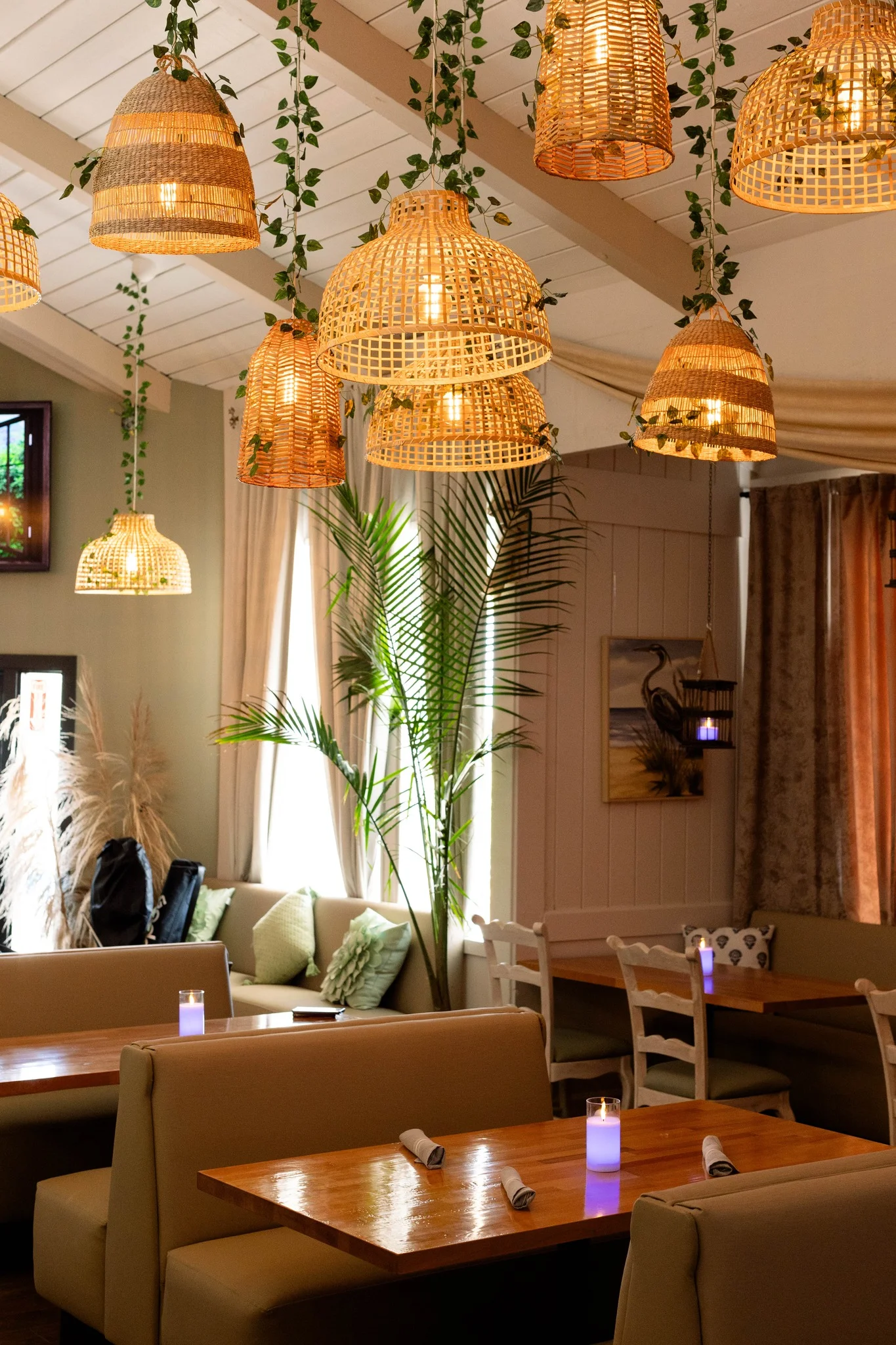 Cozy restaurant interior with woven pendant lights and greenery