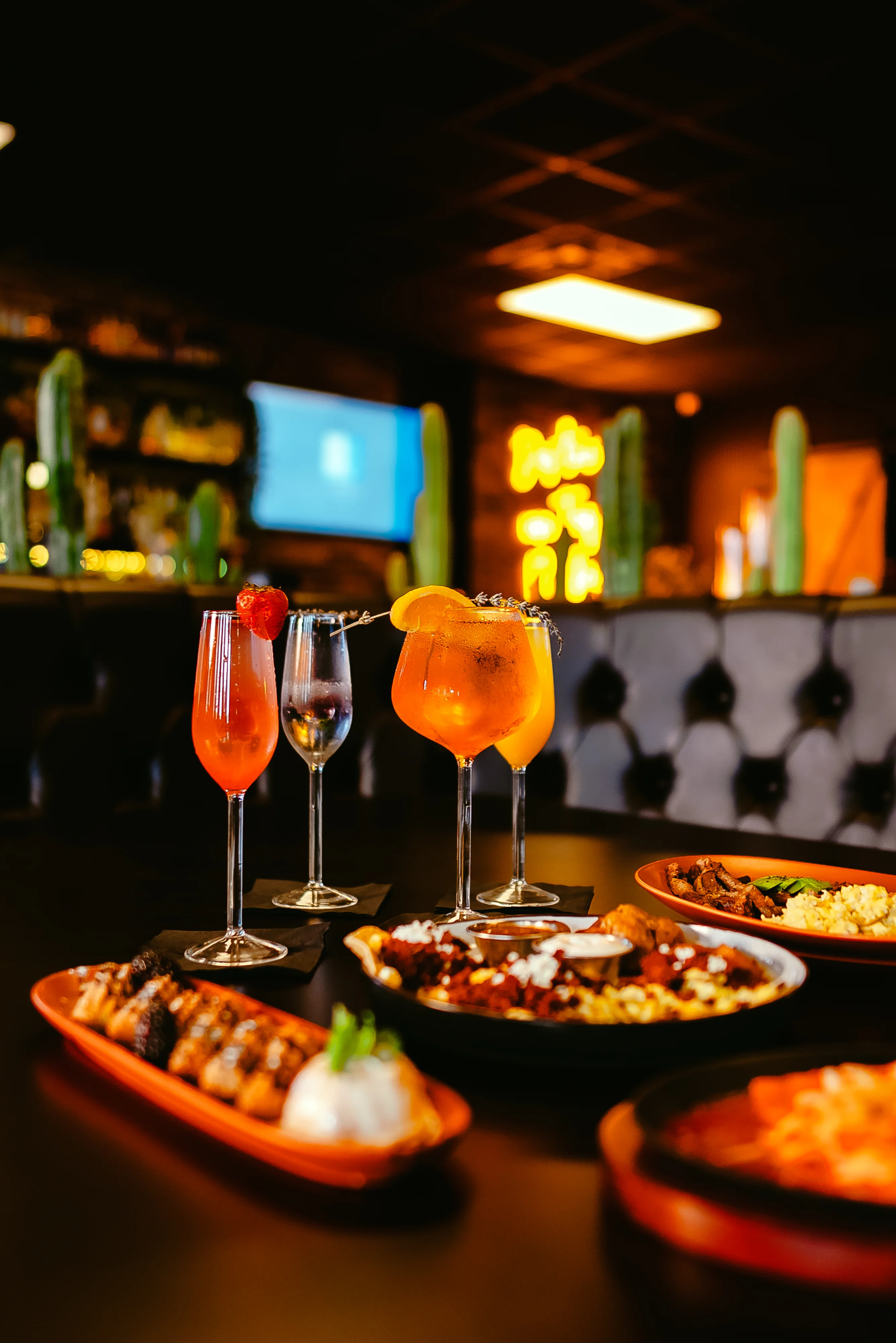 Colorful cocktails and vibrant dishes in a lively restaurant setting