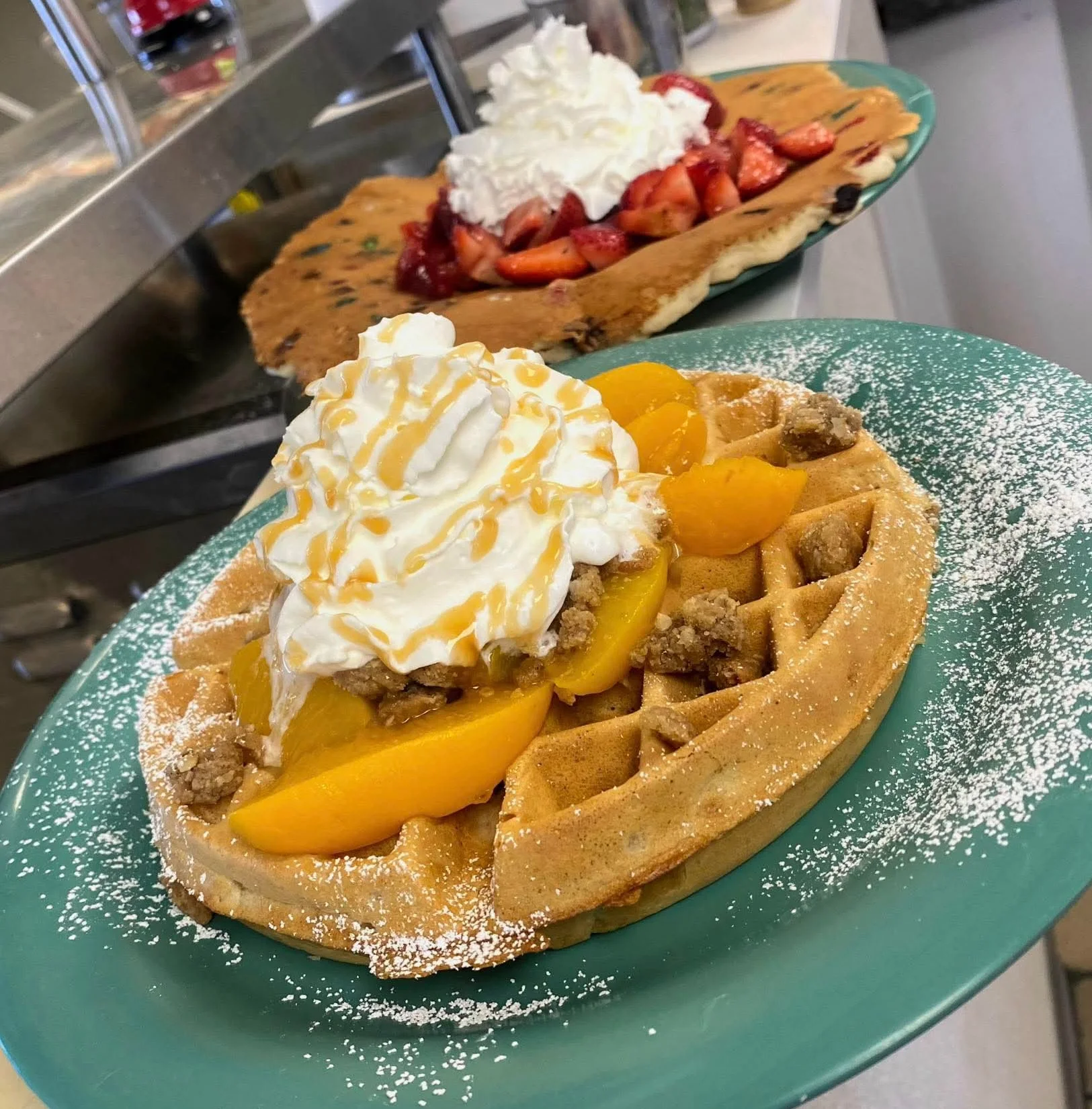 Delicious peach waffle topped with whipped cream and caramel drizzle