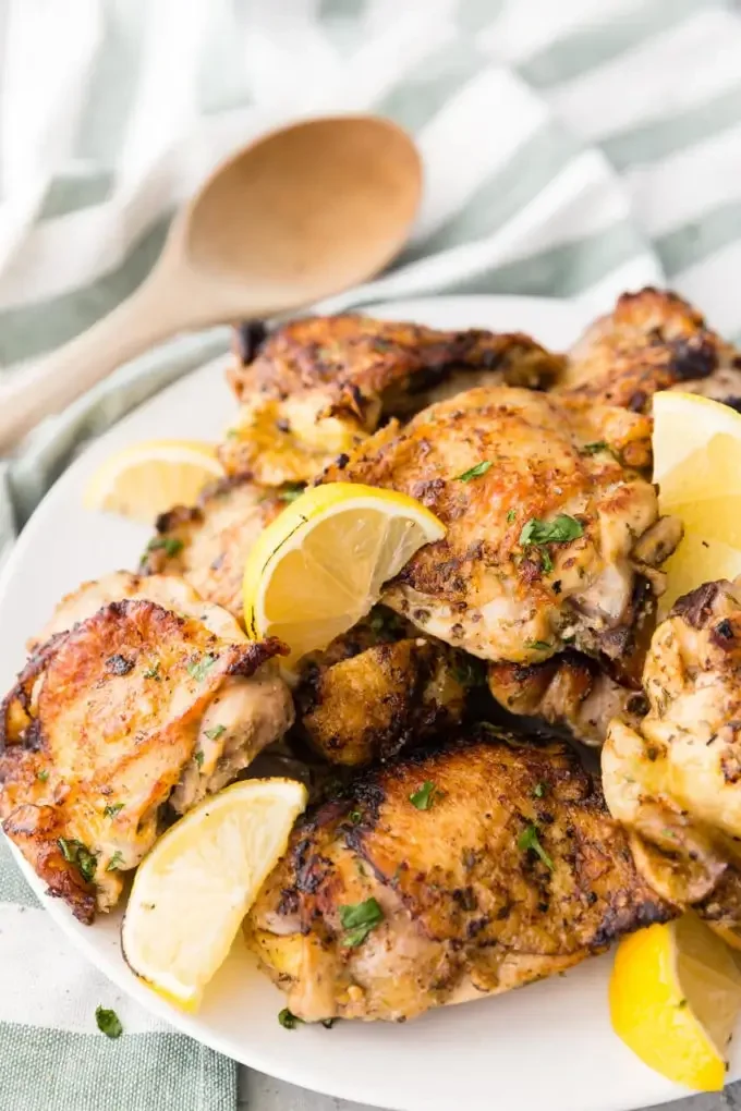 Grilled lemon herb chicken thighs on a platter