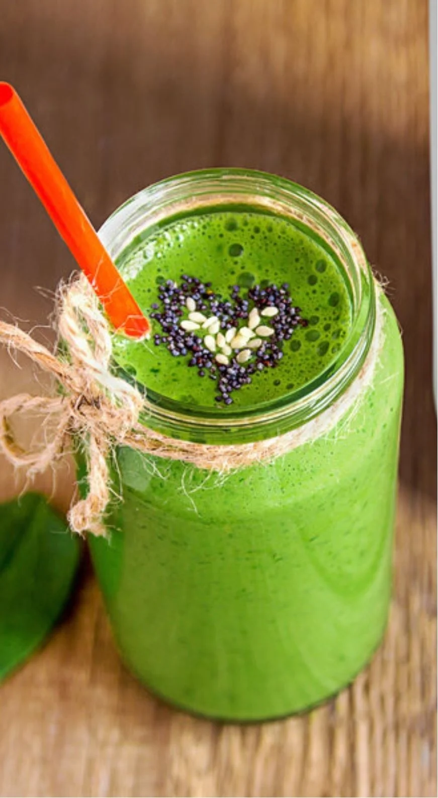 Green smoothie with heart-shaped toppings in a jar