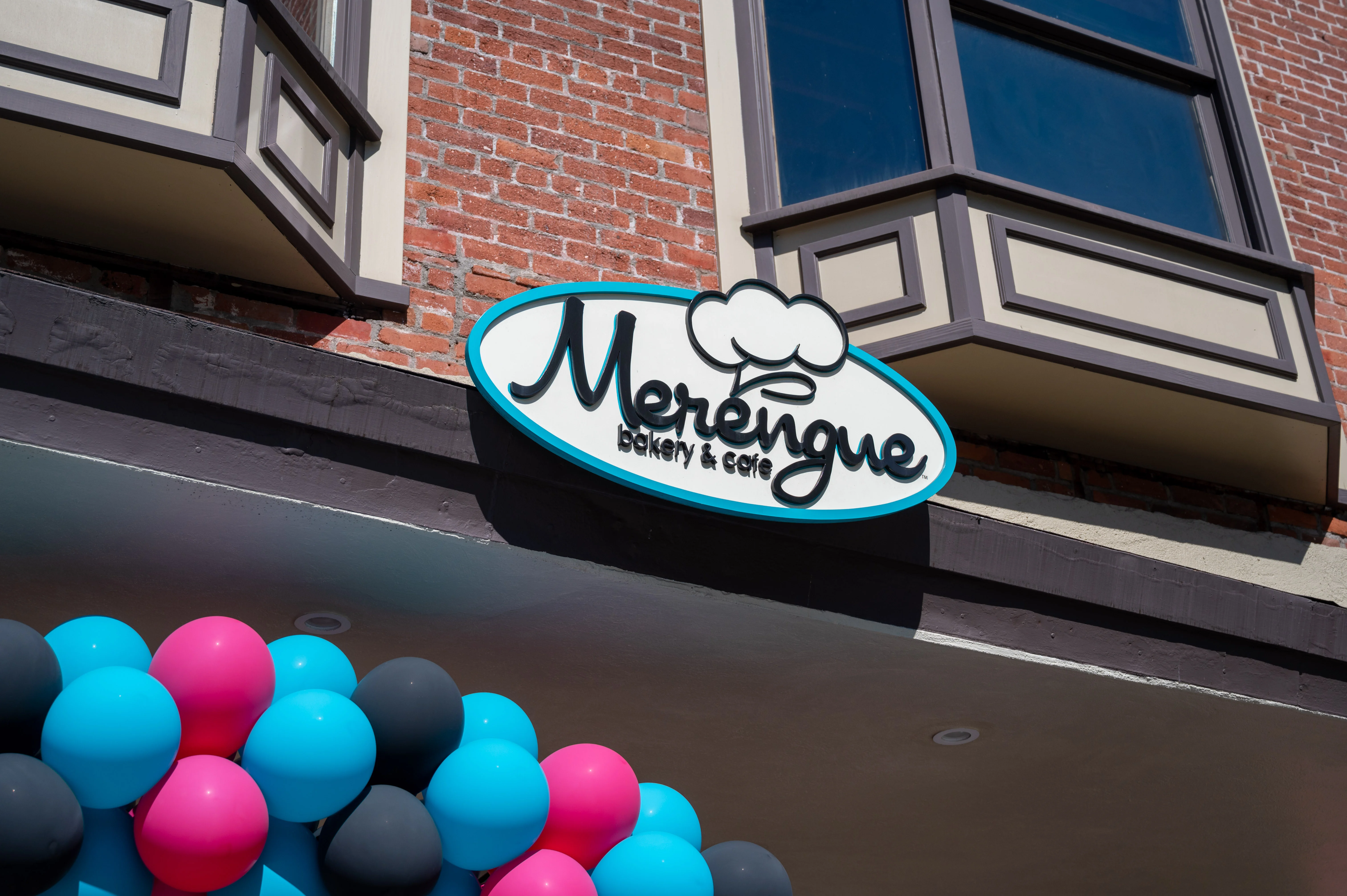 Signage of Merengue Bakery & Cafe with colorful balloons