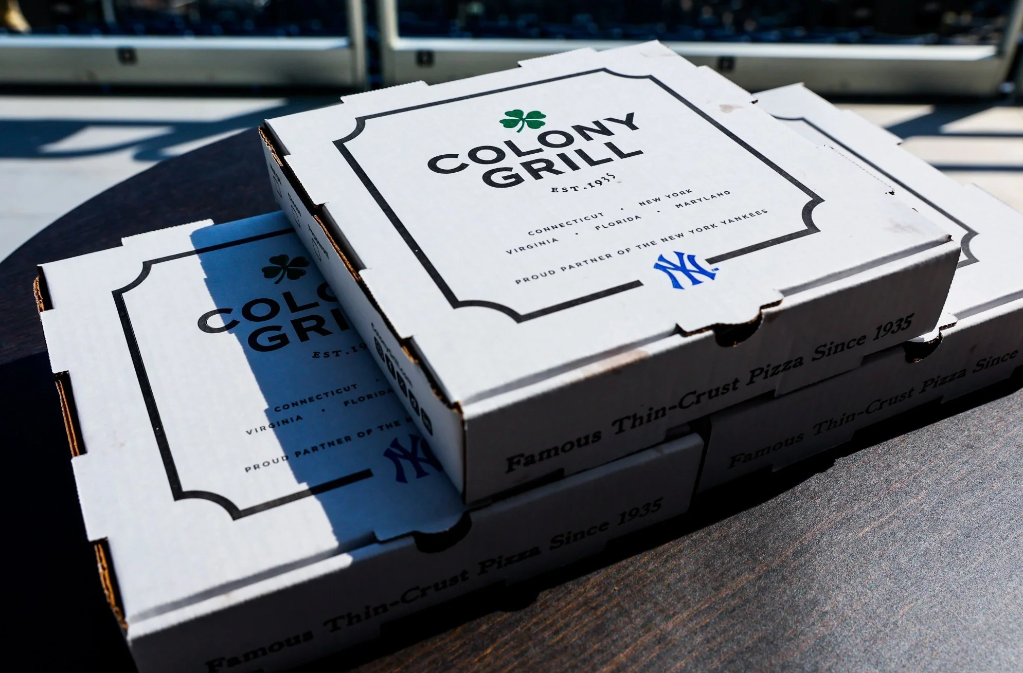 Colony Grill pizza boxes stacked on a table
