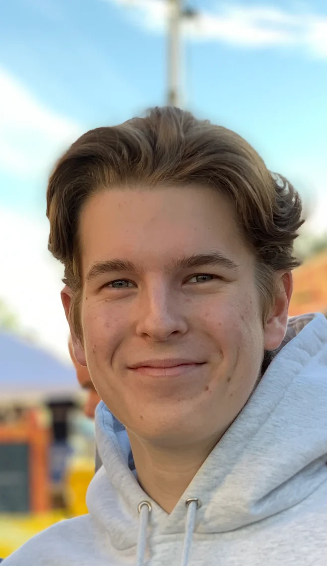 Smiling young man in a casual hoodie outdoors