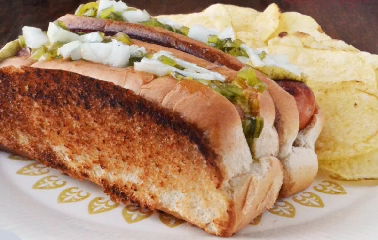 A delicious New England hot dog topped with various condiments.