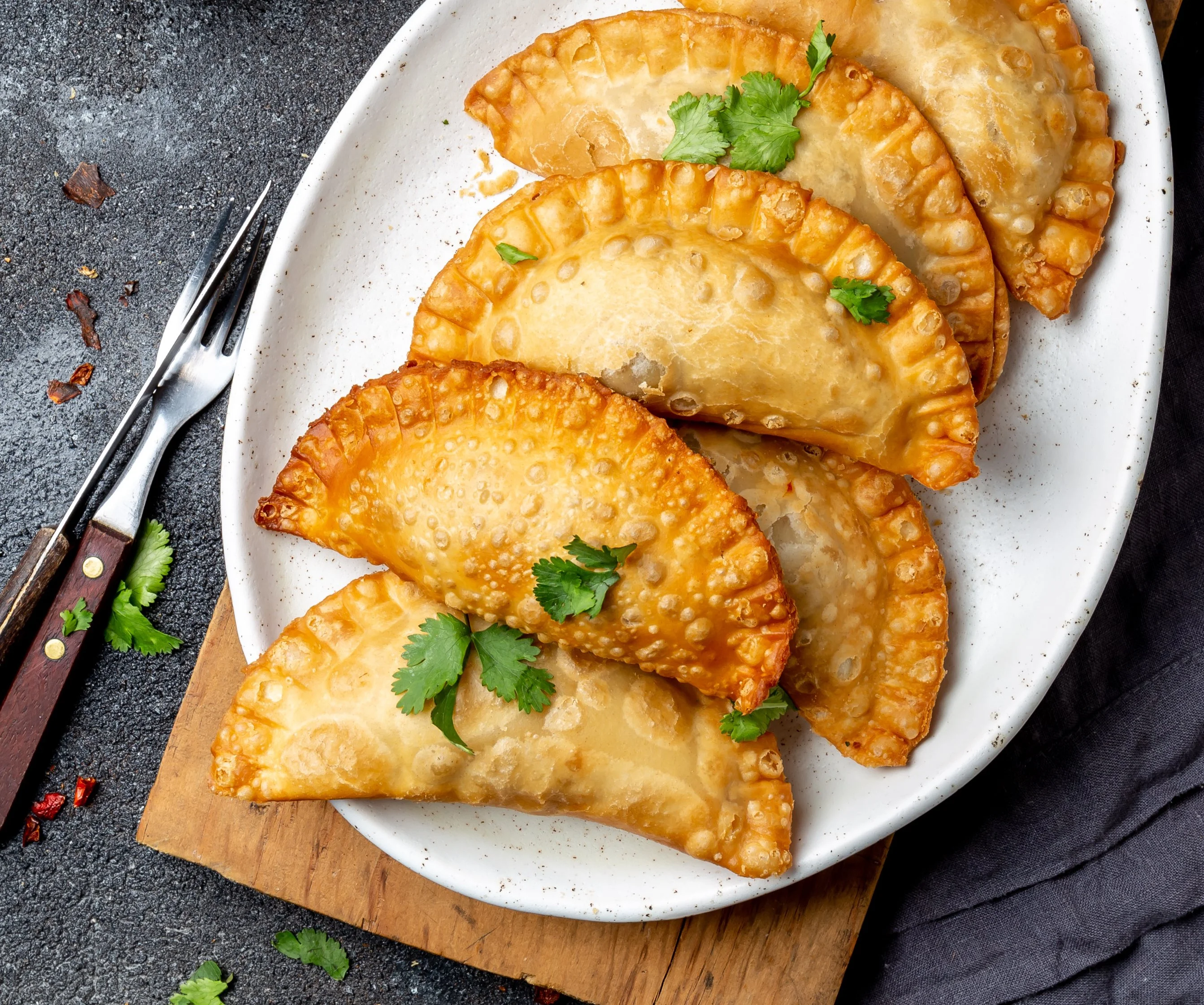 Golden empanadas served on a white plate