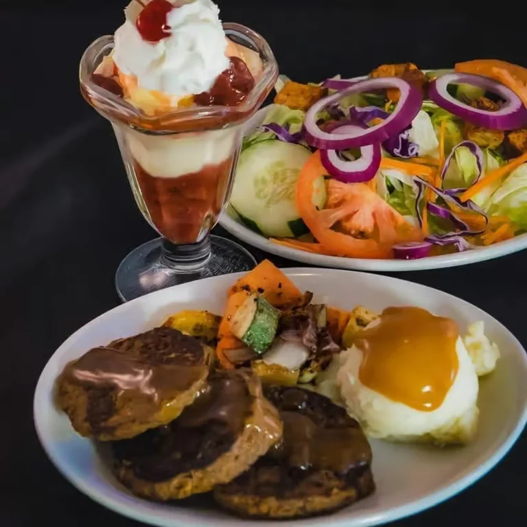 Moonlite Diner dinner special featuring Salisbury steak with gravy, mashed potatoes, vegetables, a fresh garden salad, and a classic ice cream sundae.