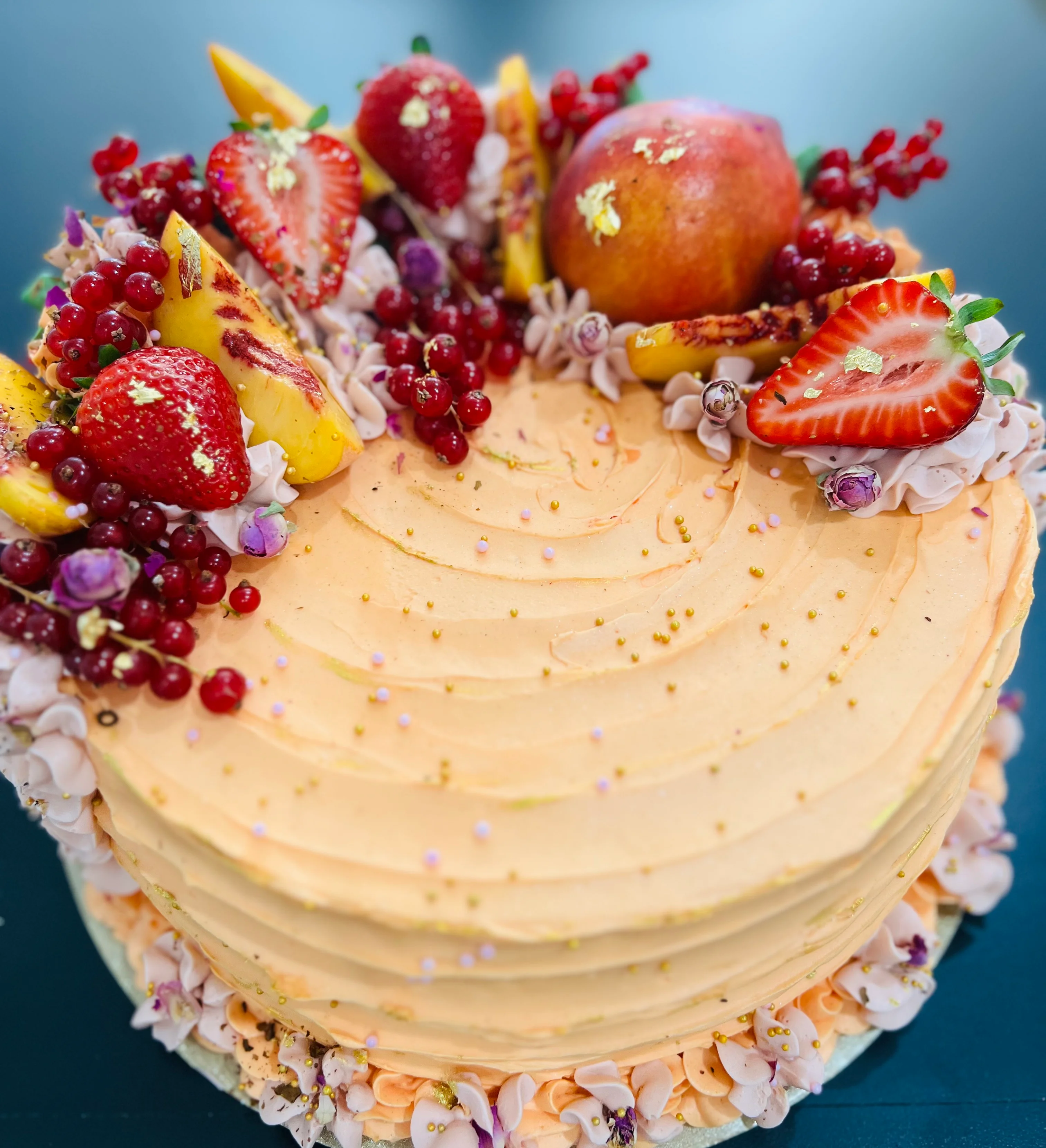 Elegant fruit cake decorated with fresh berries and flowers