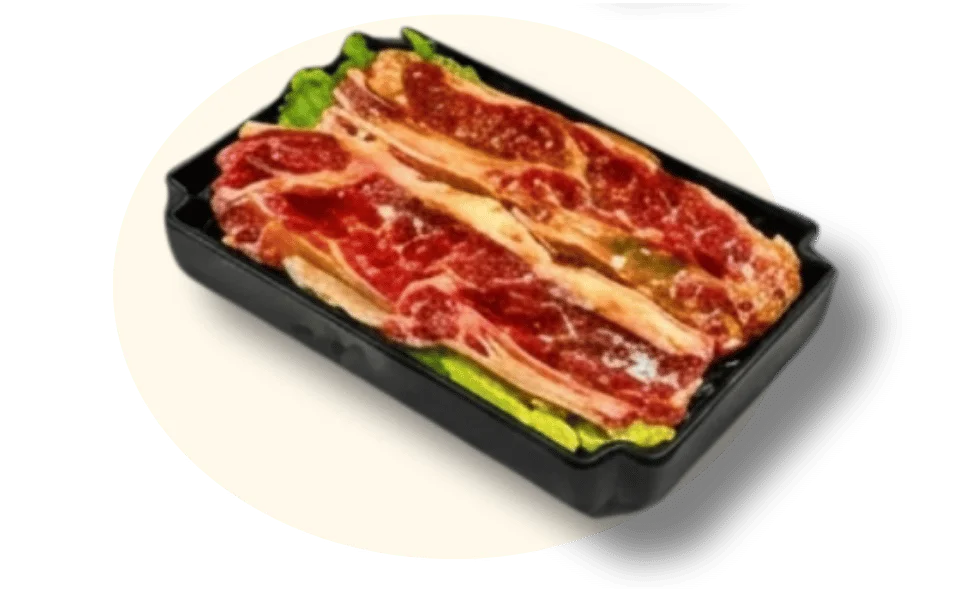 Platter of marbled beef slices on a bed of lettuce in a black tray.