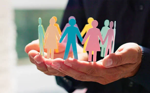 Colorful paper figures held in hands symbolizing community and connection