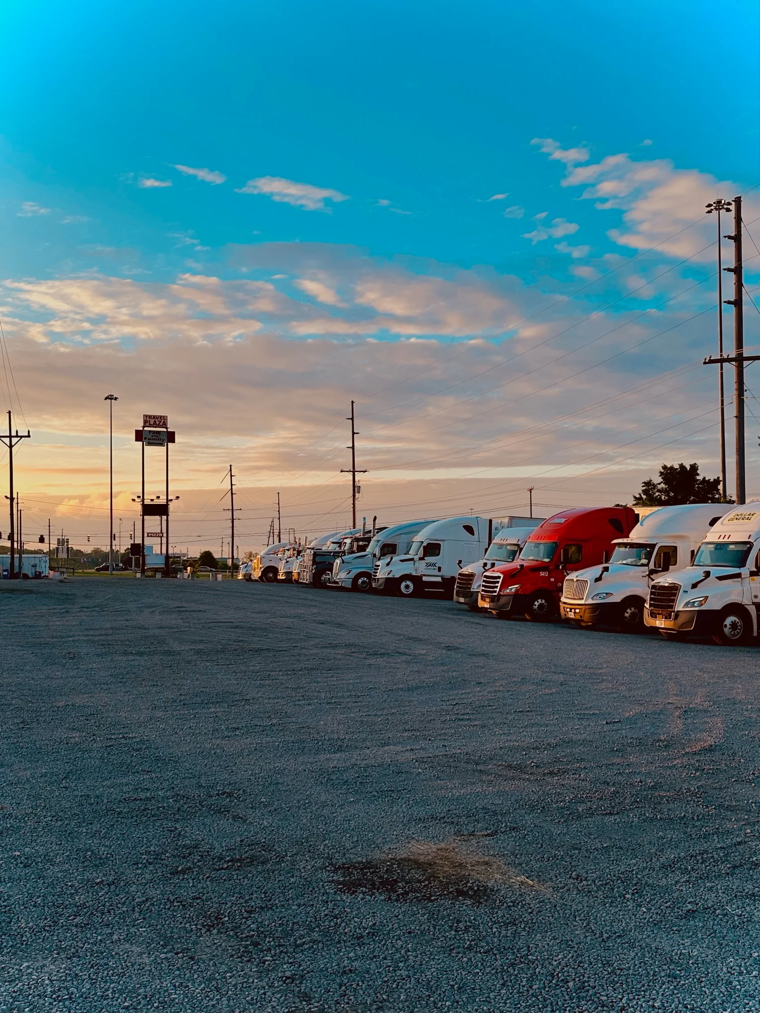 Trucks parked under a colorful sunset sky