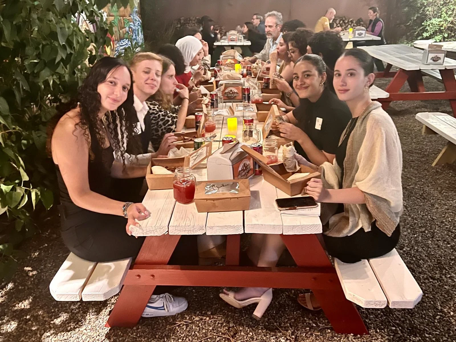 Group of friends enjoying a meal at a rustic outdoor dining setting