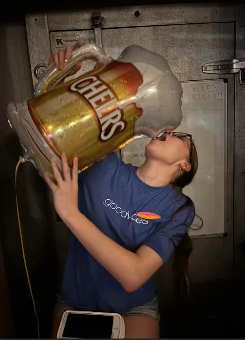 Person enjoying a giant beer mug balloon in a fun setting