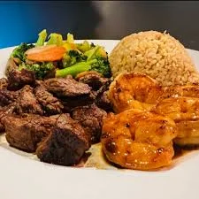 Grilled steak and shrimp platter with rice and vegetables