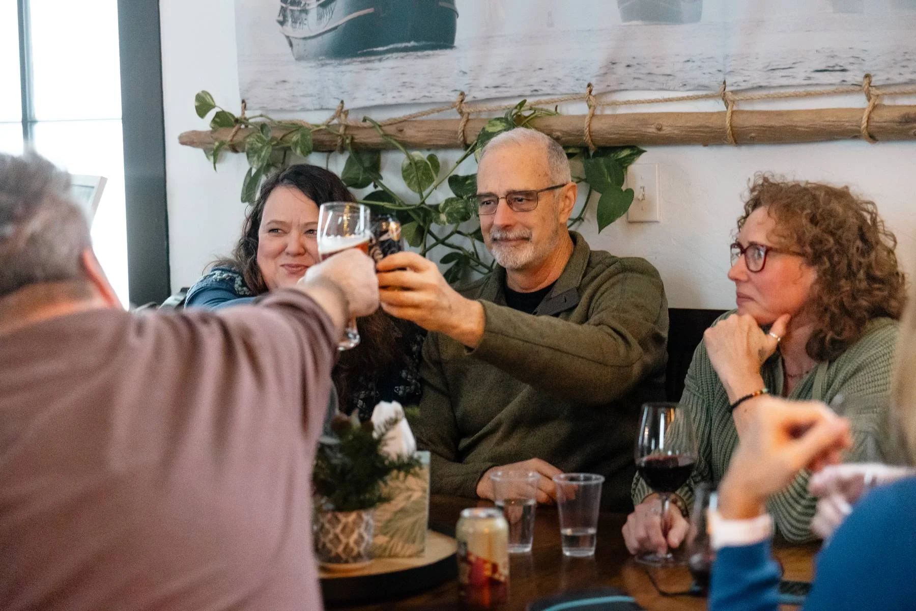 Group of friends toasting drinks in a cozy restaurant setting