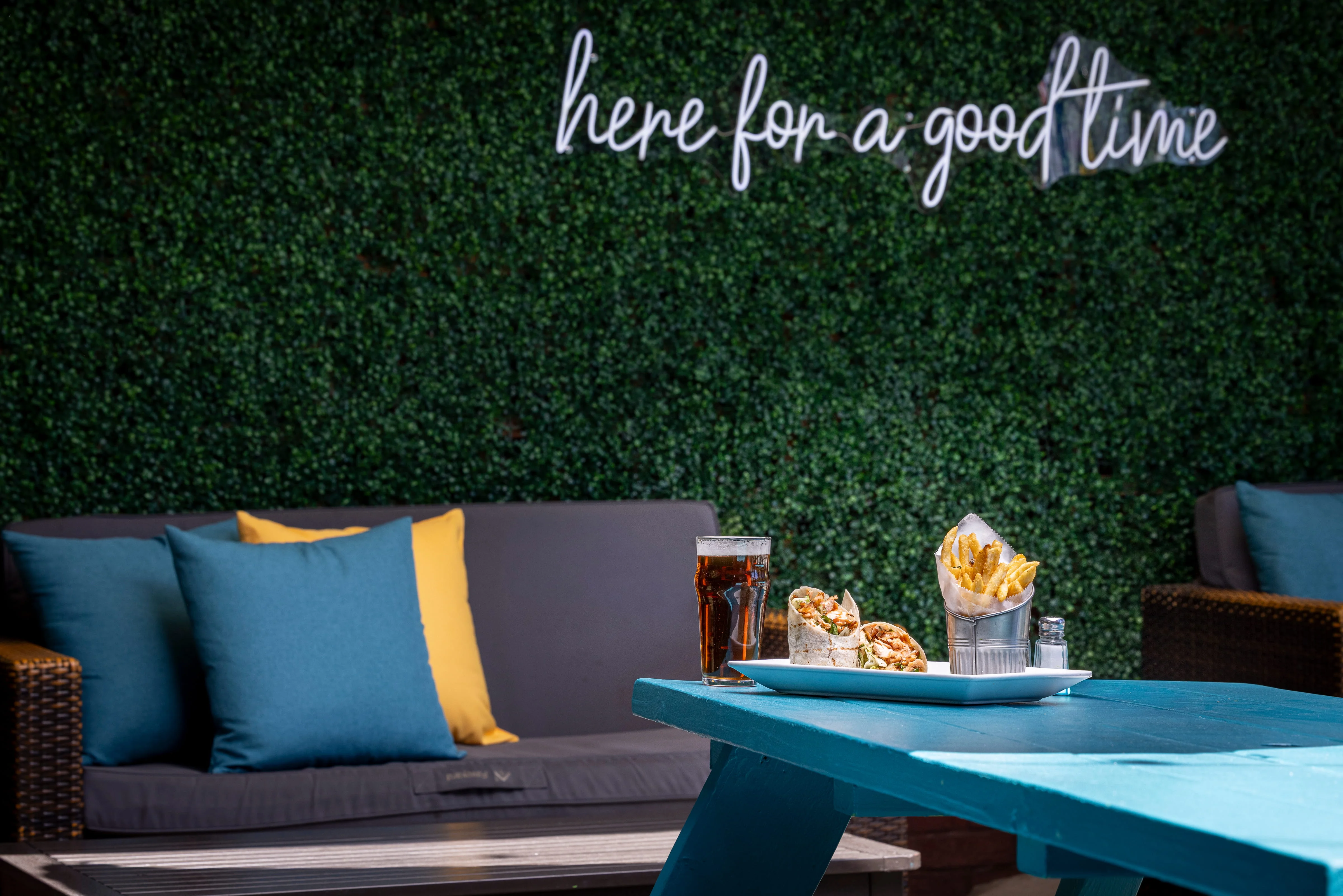 Outdoor dining setup with wraps and fries on a blue table