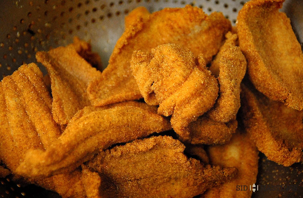 Crispy fried catfish fillets in a colander