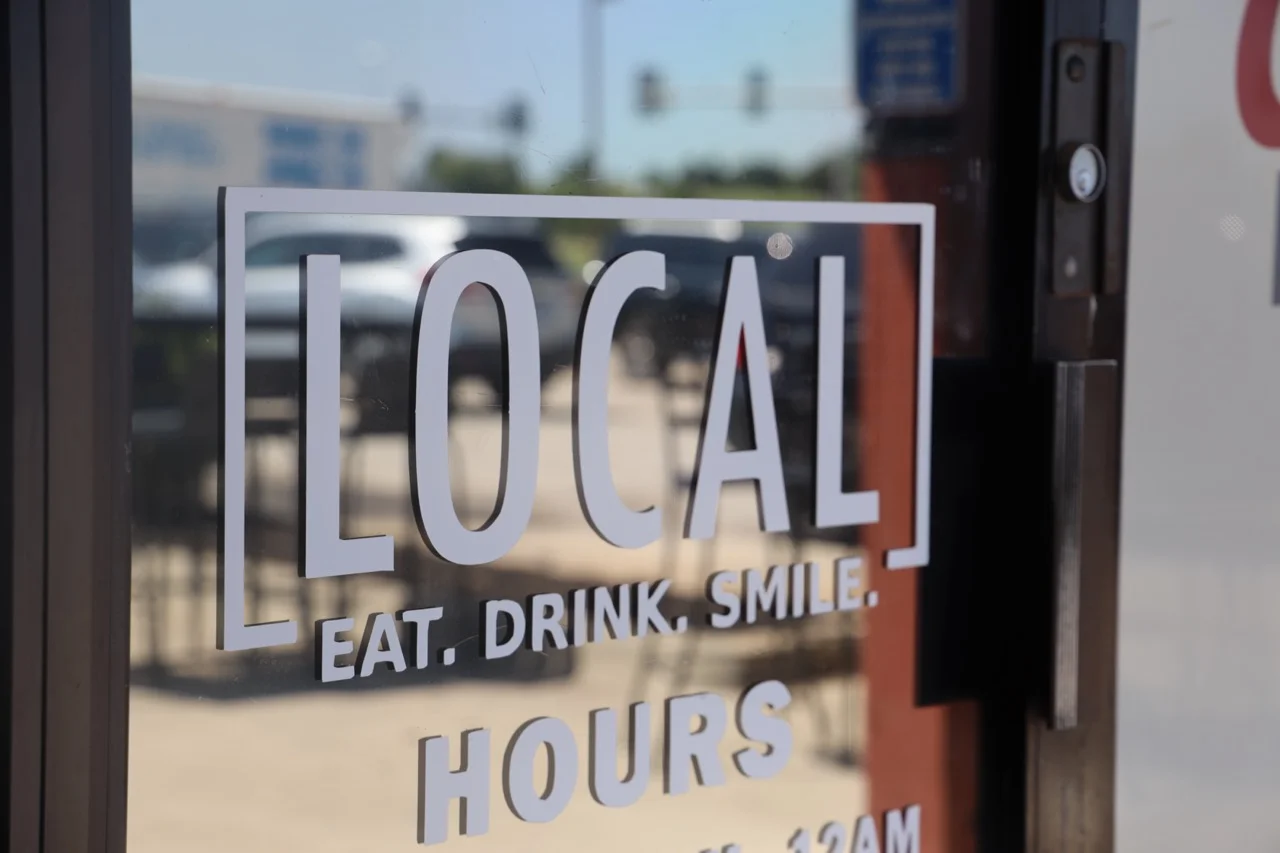 Front door sign at the local - with a sign that says Local - Eat. Drink. Smile. 