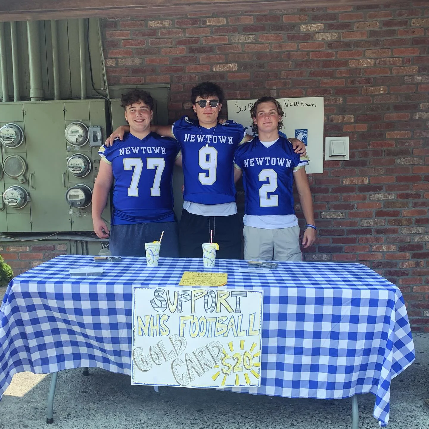 Students promoting Newtown High School football with a fundraising table