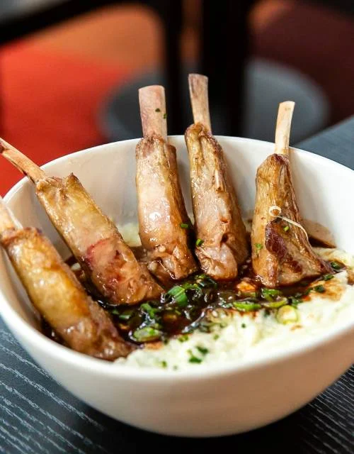 Tender lamb chops with savory sauce served over creamy polenta