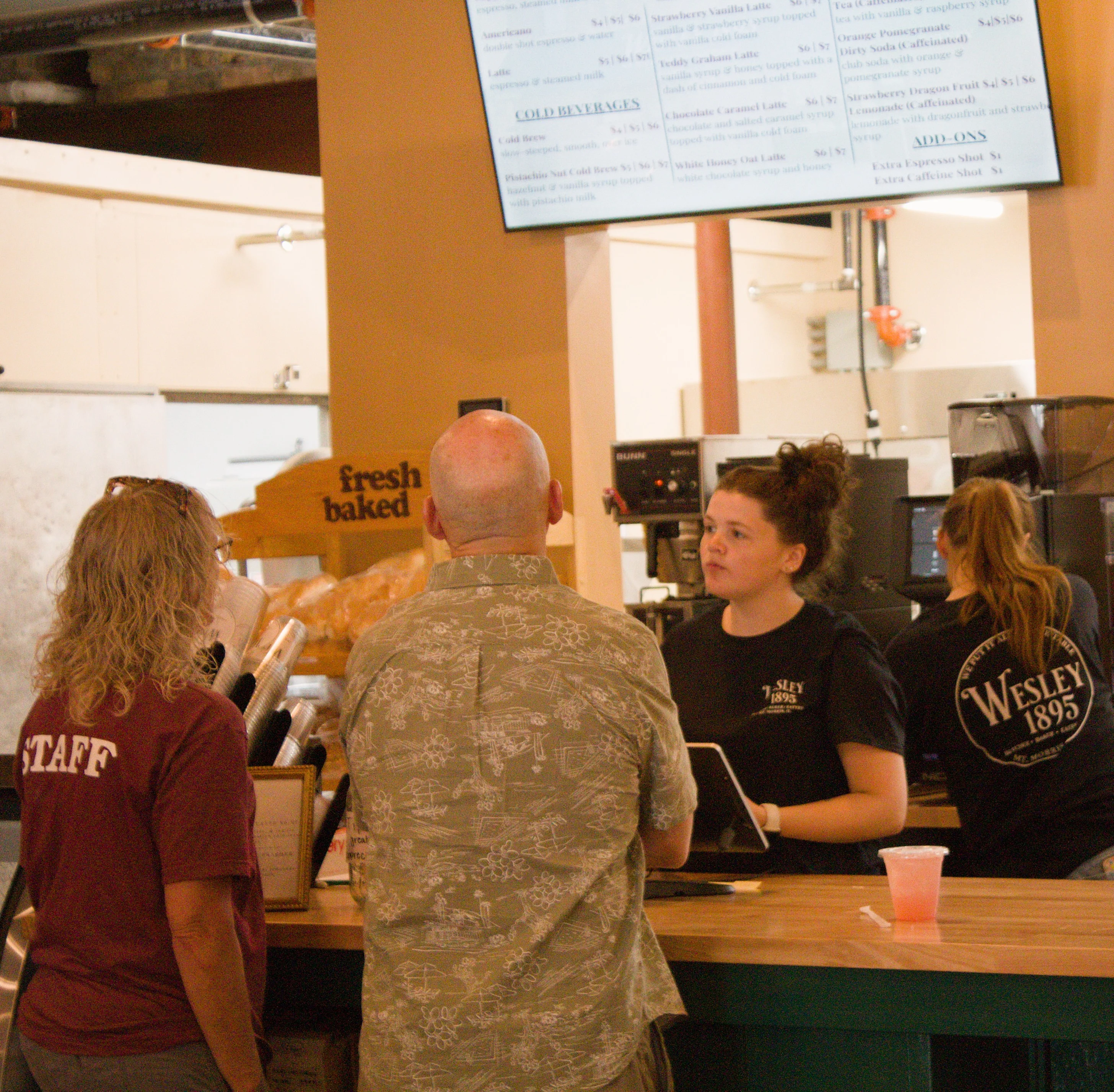 Staff serving customers at a cozy café counter