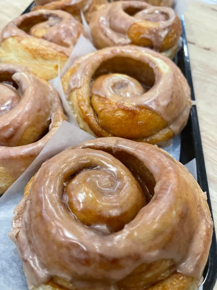 Assorted pastries including cinnamon rolls and muffins on a platter