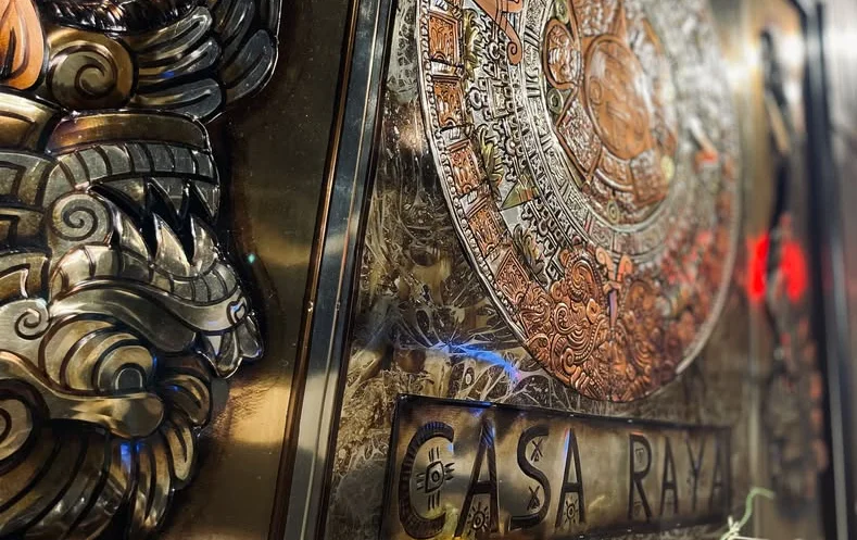 Intricate metal artwork featuring the Aztec calendar at Casa Raya restaurant
