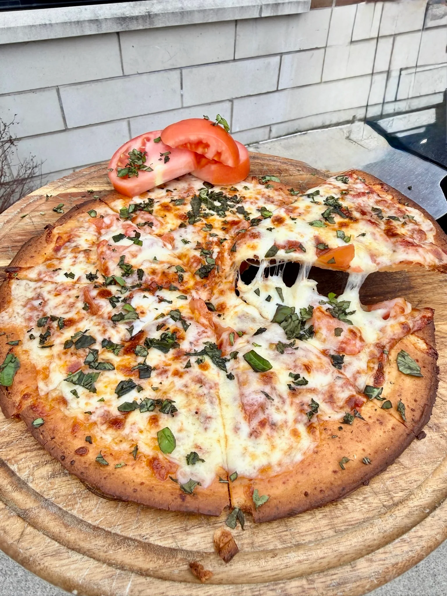 Cheesy Margherita pizza with fresh basil and tomato slices
