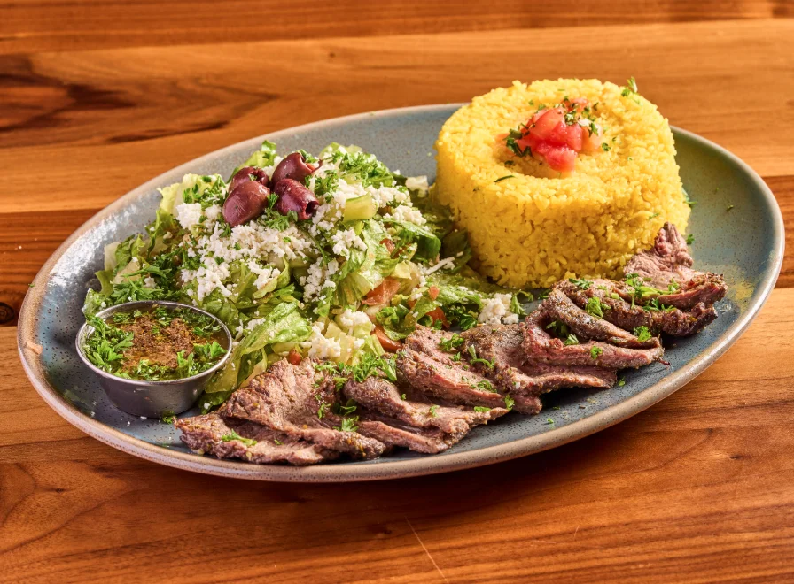 Churrasco skirt steak platter with grilled skirt steak with chimichurri sauce.