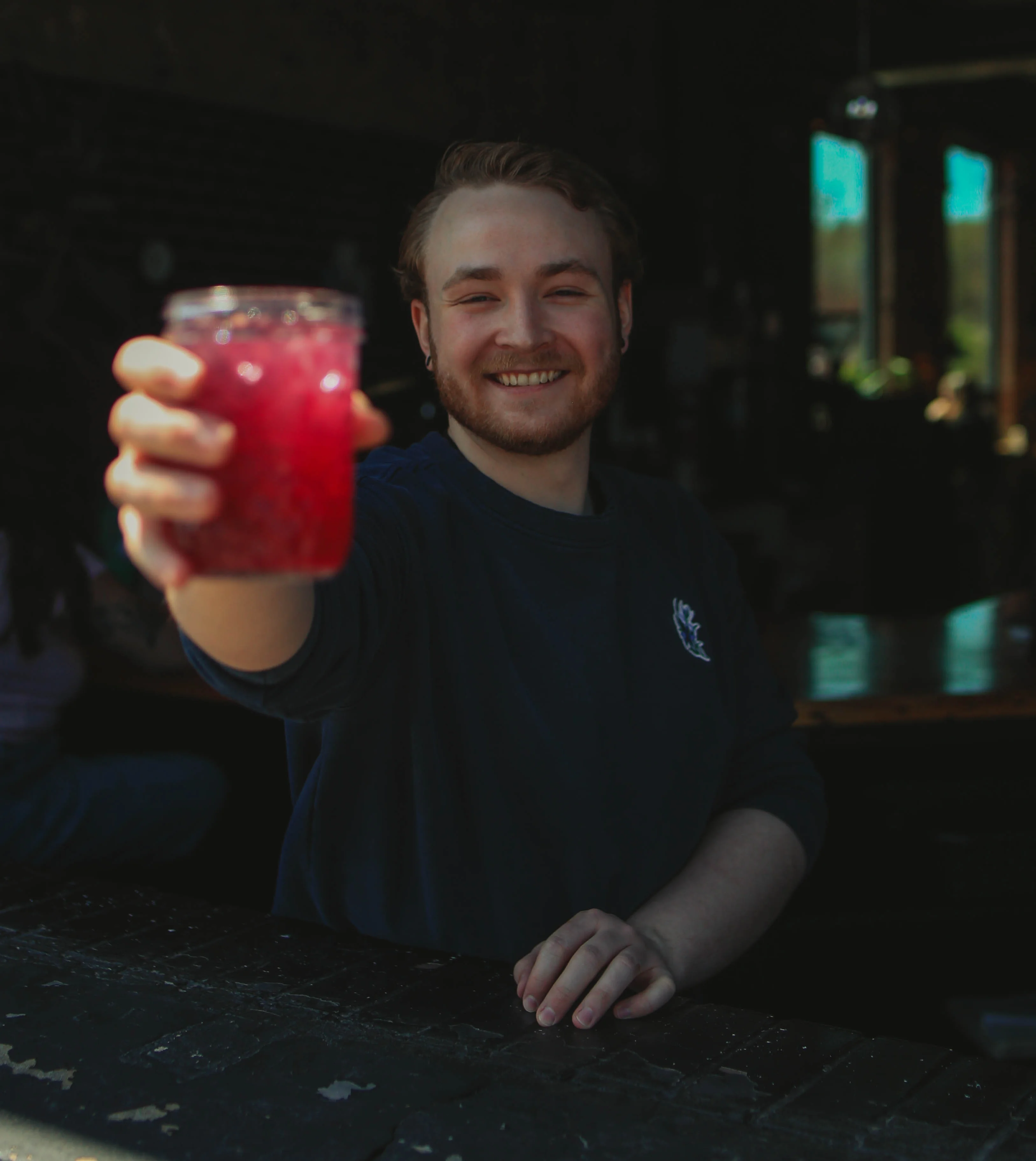 Bartender serving a vibrant cocktail at a trendy bar