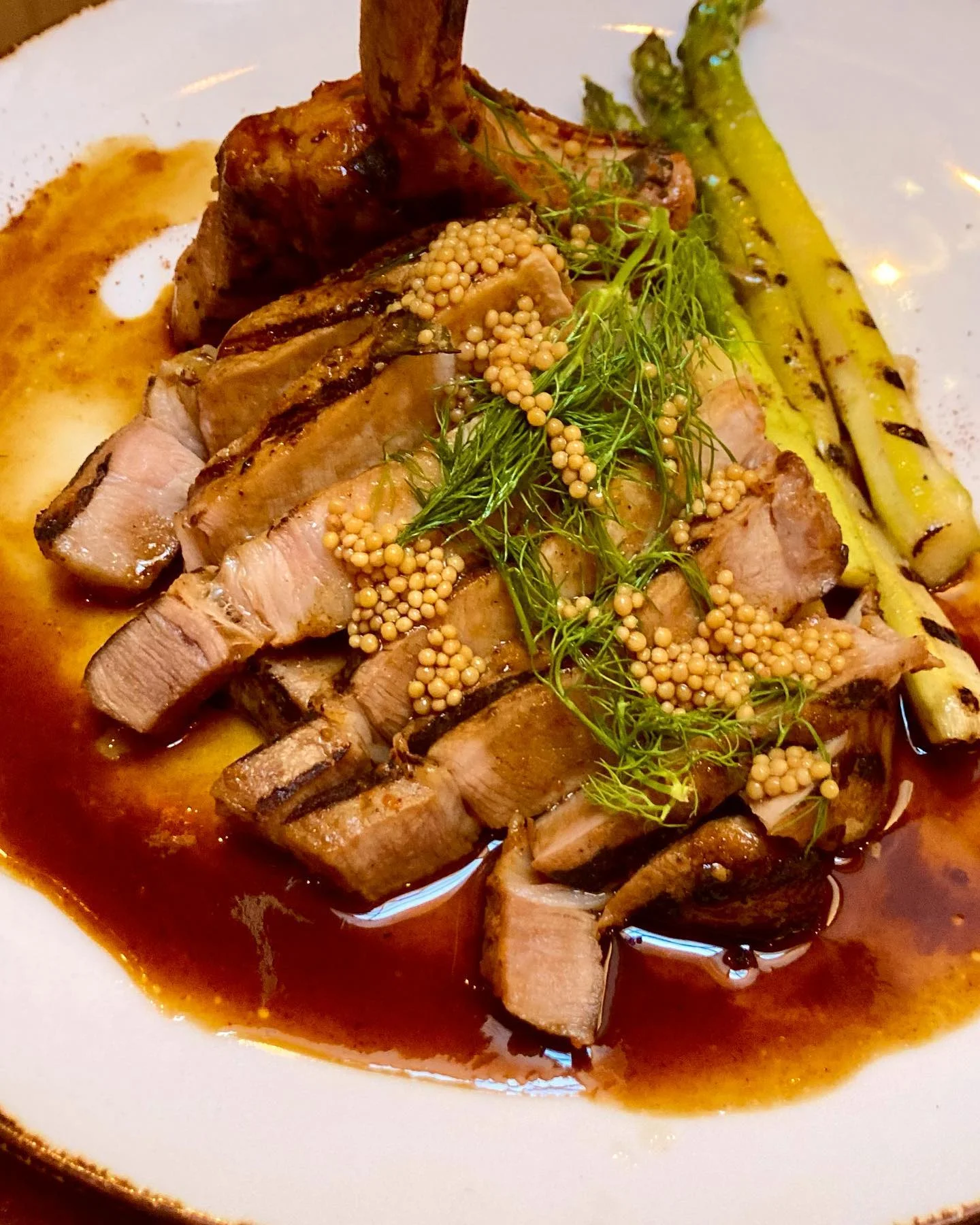 Sliced duck breast with mustard seeds and grilled asparagus